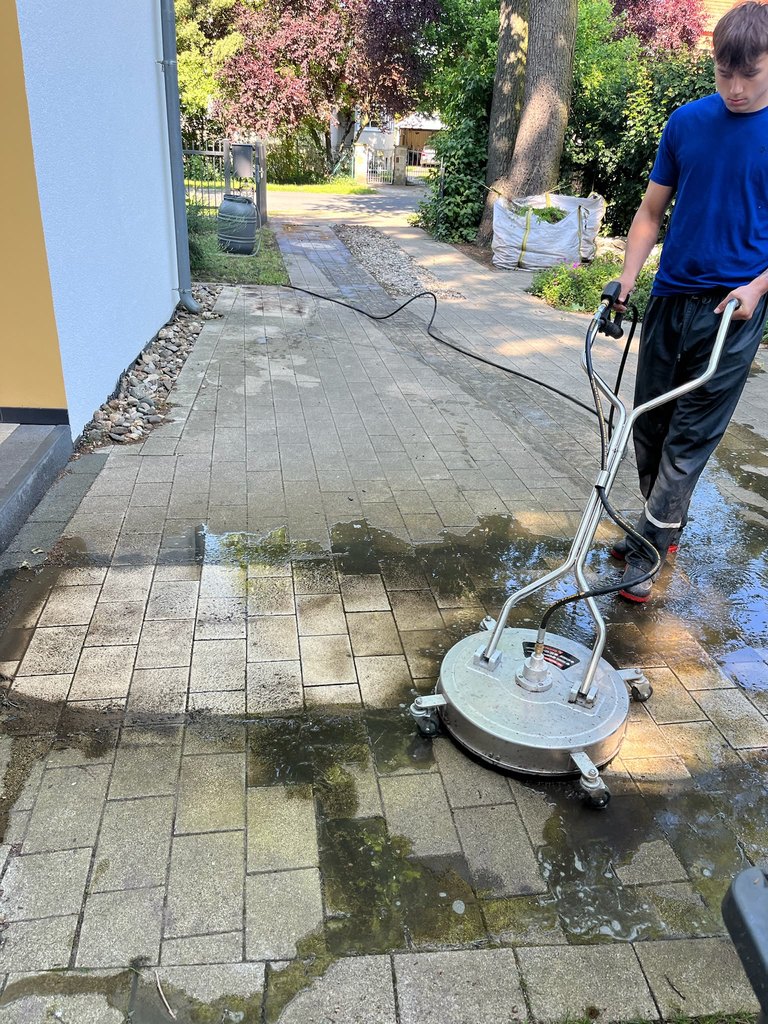 Pflasterfläche halb gereinigt, halb verschmutzt — echtes Arbeitsfoto